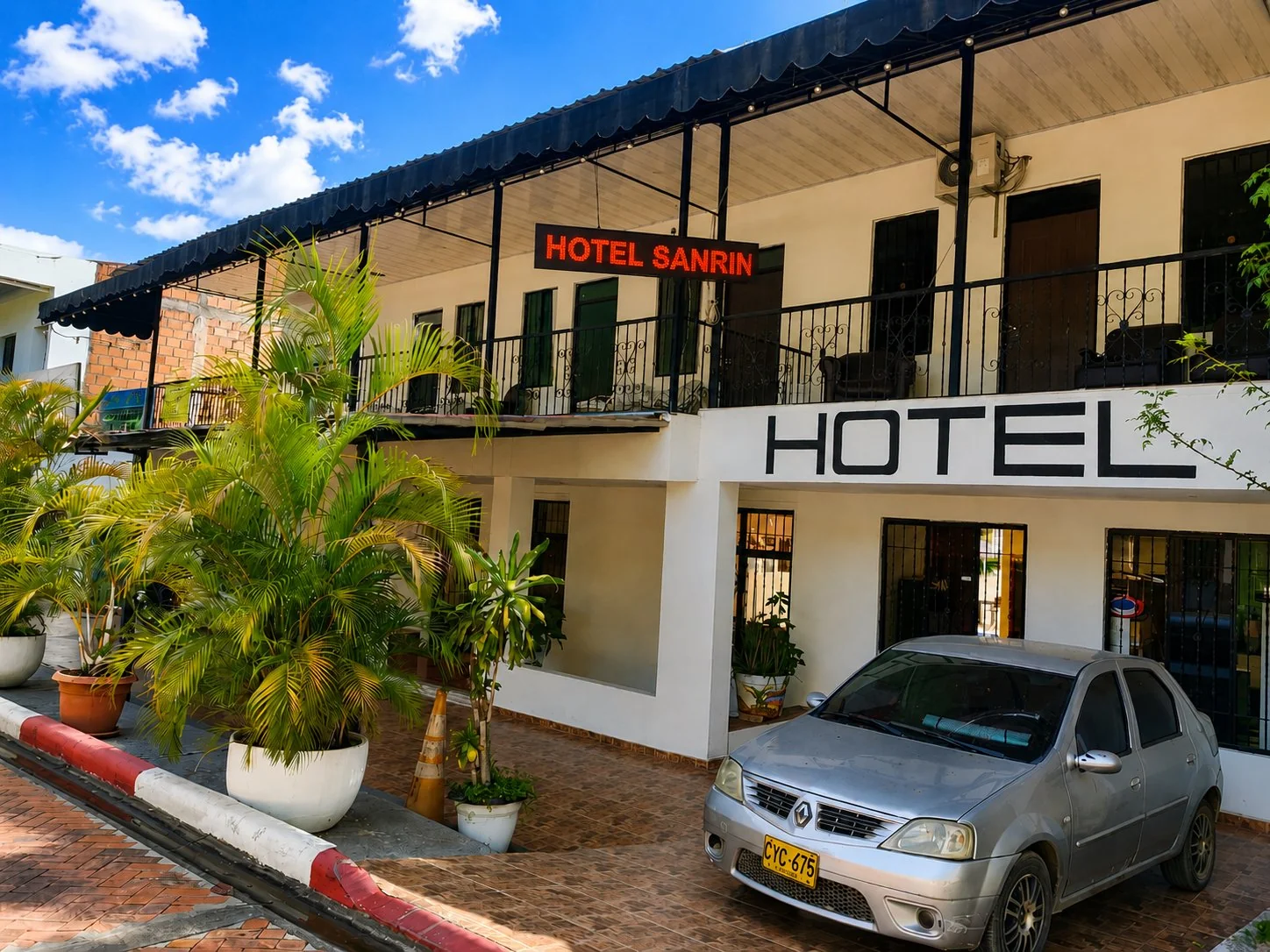 Fachada del Hotel San Rin en Nilo con palmeras